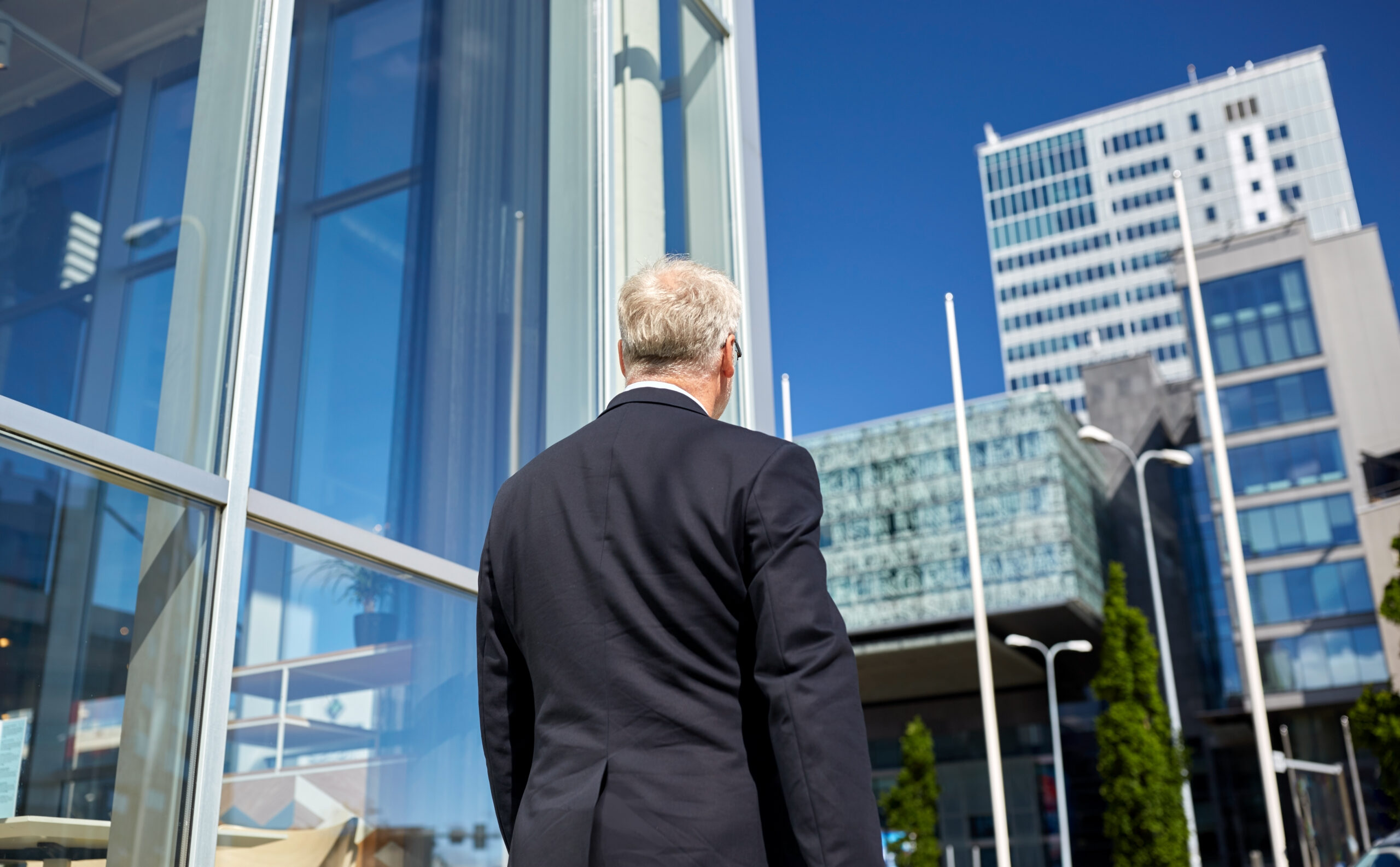 business and people concept - senior businessman walking along city street